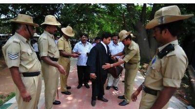 An Indian policeman checks people's identification cards and personal belongings, in front of Karnataka High Court, Bangalore as the city is put on high alert after a bomb blast in Delhi the previous day. JAGADEESH NV / EPA