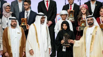 Sheikh Mohammed bin Zayed, Crown Prince of Abu Dhabi and Deputy Supreme Commander of the UAE Armed Forces, third right, and Sheikh Mohammed bin Rashid, Vice President and Ruler of Dubai, right, present an award to a winner during the Sheikha Fatima bint Mubarak Awards for Excellence and Social Creativity, at Emirates Palace. They are seen with Ali bin Salem Al Kaabi, Director of the Office of the Minister of Presidential Affairs and Chairman of the Board of Trustees of the Family Development Foundation, left. Rashed Al Mansoori / Crown Prince Court - Abu Dhabi