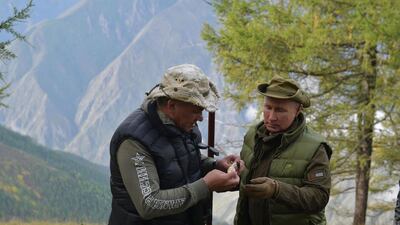 Russian President Vladimir Putin speaks with Defence Minister Sergei Shoigu during their leisure time in the Siberian Taiga area. AFP