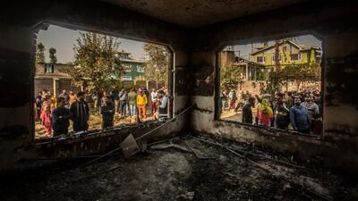 Kashmiris assemble near a house damaged after a gunbattle in Srinagar, Indian controlled Kashmir. AP Photo