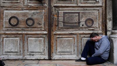 A visitor prays outside the closed gate to the Church of the Holy Sepulchre in the Old City quarter of Jerusalem, on February 26, 2019. Abir Sultan / EPA