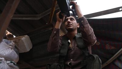 In this file photo taken on October 09, 2018 shows a Syrian rebel-fighter aiming his machine gun on the Idlib frontline with regime forces. AFP