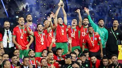 Morroco's players celebrate with the trophy after winning the FIFA Arab Cup 2025 final football match between Jordan and Morocco at the Lusail Stadium Stadium, in Lusail on December 18, 2025. (Photo by Karim JAAFAR / AFP)