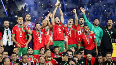 Morroco's players celebrate with the trophy after winning the FIFA Arab Cup 2025 final football match between Jordan and Morocco at the Lusail Stadium Stadium, in Lusail on December 18, 2025. (Photo by Karim JAAFAR / AFP)