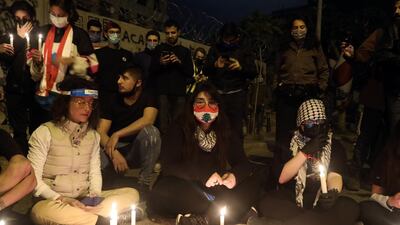 Protesters wearing protective face masks light candles during an anti-government demonstration outside the headquarters of the Lebanese central bank in Beirut. Bloomberg