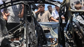 People surround a vehicle hit by an Israeli strike in Gaza city on Monday. Reuters