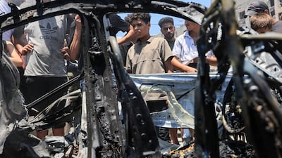 People surround a vehicle hit by an Israeli strike in Gaza city on Monday. Reuters