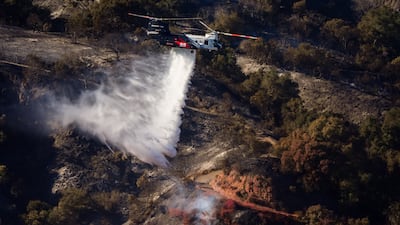 A helicopter drops water on hotspots in the Palisades Fire in Los Angeles, California. Bloomberg