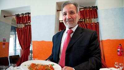 Ahmed Aslam Ali, at his Shish Mahal restaurant in Glasgow, shows a plate of chicken tikka masala. AFP