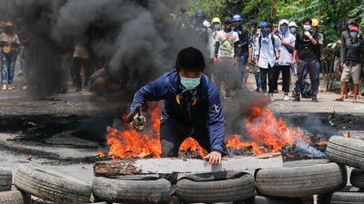A man stands behind a barricade during a protest against the military coup in Yangon. Reuters