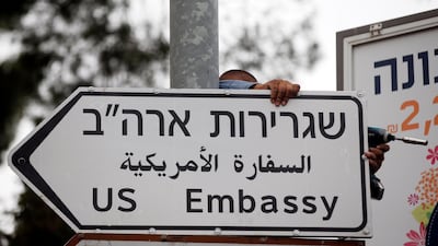 A worker hangs a road sign directing to the US embassy in Jerusalem. Ronen Zvulun / Reuters