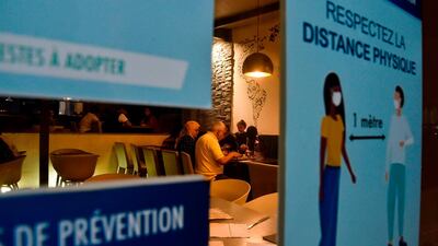 Notices are plastered at the entrance of a restaurant in Algiers, reminding customers to respect safety measures after lockdown restrictions were eased by the authorities. AFP