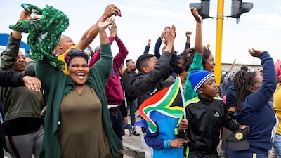 People cheer as South African Rugby World Cup winner team parades on an open top bus. AFP