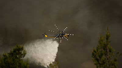 A firefighting helicopter drops water over a wildfire in the area of Porto Germeno, about 70km north-west of Athens. AFP
