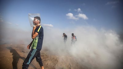 A man uses a plastic bag to protect himself from tear gas during clashes between Israeli troops and Palestinian protesters. EPA