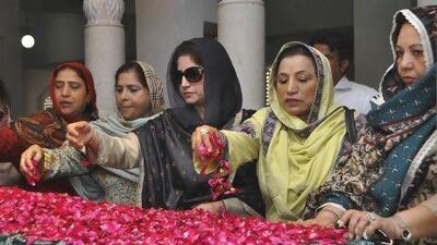 Pakistan Peoples Party supporters scatter rose petals on the grave of Pakistan's former prime minister Benazir Bhutto during anniversary commemorations at the Bhutto family mausoleum.