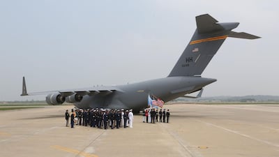 UN honour guards prepare to carry remains of US servicemen. AFP