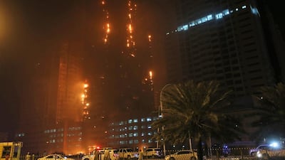 Fire and smoke billow from Ajman One at the end of March. The authorities say they are unable to identify the cause with certainty but officials’ suspicions remain. Kamran Jebreili / AP Photo