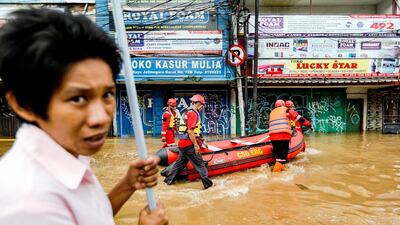 Members of a rescue team prepare an inflatable boat to evacuate locals as floods hit the Jatinegara area of Indonesia. Reuters