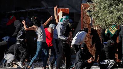 Palestinian demonstrators throw rocks at Israeli police at Jerusalem's Al Aqsa Mosque compound. AFP