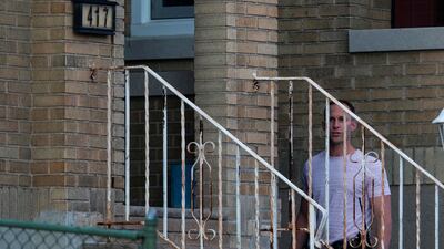 A plain-clothed police officer stands near the entrance of the building where Mr Matar lives in Fairview, New Jersey. Reuters