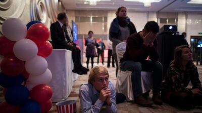 People react as they watch news on a screen on the final day of the US presidential election at an event organised by the American consulate in Shanghai. Johannes Eisele / AFP