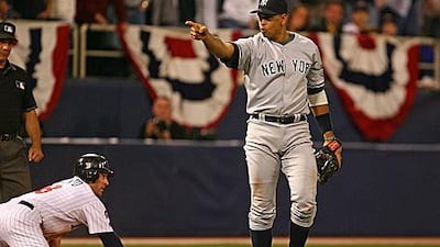 Alex Rodriguez points to a teammate after tagging out the Twins' Nick Punto at third.