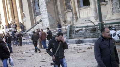 Egyptian policemen at the site of a suspected car bomb explosion outside Cairo police headquarters on Friday. AFP