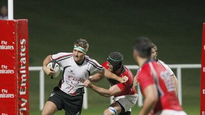 While playing for the UAE, Renier Els, left, fights off a Hong Kong defender during action at The Sevens. Mike Young / The National