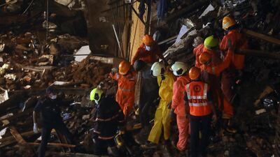 National Disaster Response Force and fire brigade personnel help a man rescued from the rubble. Reuters