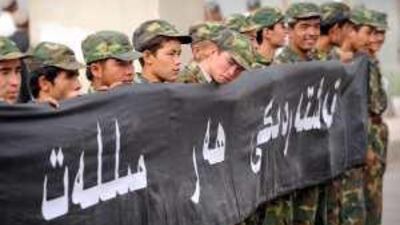 Ethnic Uighur soldiers hold a banner for an official ceremony to remember the 16 Chinese police officers killed in an alleged terrorist attack.