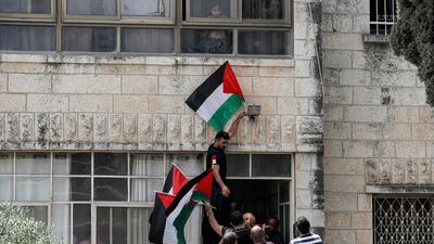 People gather with Palestinian flags outside the family home of the deceased Al Jazeera journalist. AFP