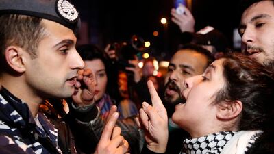 An anti-government protester, right, argues with a police officer, as protesters blocking a main road during ongoing protests against corruption, in Beirut, Lebanon. AP