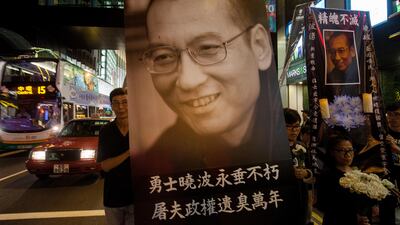 Supporters hold a large portrait of the deceased Chinese dissident and Nobel peace prize laureate Liu Xiaobo, as they march through the streets of Hong Kong to demand the release of his widow, Liu Xia