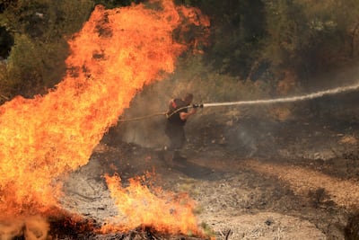A firefighter douses flames near the town of Delvine, in Albania. AFP