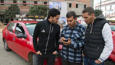 Moroccan taxi drivers check the Uber app as they wait for customers in Casablanca on January 6, 2017. In Casablanca taxi drivers are at war with Uber, demanding the government take action against the American company. Fadel Senna/AFP