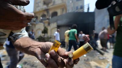 An Egyptian man holds used bullet casings outside the burnt headquarters of the Muslim Brotherhood in the Moqattam district of Cairo, Egypt. Khaled Desouki / AFP