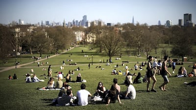 People relax on Primrose Hill, London, after the easing of lockdown rules on Monday. Half of England's population were likely to have had Covid antibodies by mid-March. Reuters