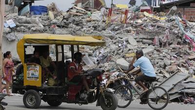 A motor cart drives by a collapsed buildings in Pedernales after the strongest earthquake to hit Ecuador in decades flattened buildings and buckled highways along its Pacific coast. Dolores Ochoa / AP Photo