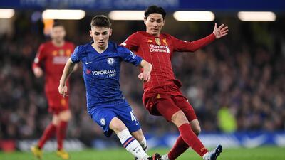 Billy Gilmour shields the ball from Takumi Minamino. AFP