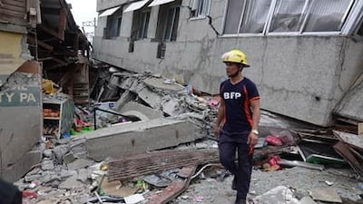 A fireman inspects a damaged market in the quake-hit town of Padada, Davao del Sur province, Philippines. EPA