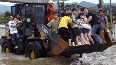 Residents of Cangnan in eastern China are rescued by a bulldozer on Monday after rains from Typhoon Morakot, which means emerald in Thai, caused a landslide. Entire blocks of buildings were washed away in the torrent.