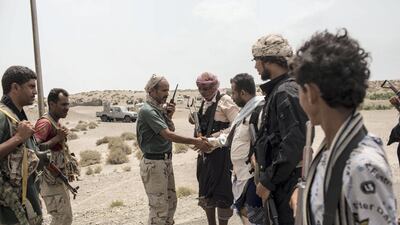 Former marine and Tihama Resistance leader Ahmed Kawkabani, third from right, meets an officer from Tariq Saleh's forces close to the front line in Hodeidah, as they discuss a joint advance against the Houthis along the Red Sea coast, on May 15, 2018. Asmaa Waguih for The National 