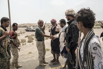 Former marine and Tihama Resistance leader Ahmed Kawkabani, third from right, meets an officer from Tariq Saleh's forces close to the front line in Hodeidah, as they discuss a joint advance against the Houthis along the Red Sea coast, on May 15, 2018. Asmaa Waguih for The National