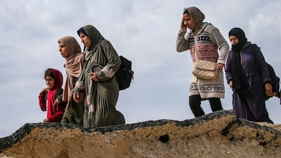 Palestinians, including women and children, cross from northern to southern Gaza along Al Rashid road. EPA
