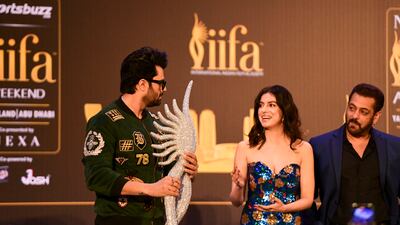 Manish Paul, Divya Khosla Kumar and Salman Khan on stage with a replica of the IIFA Awards statuette.
