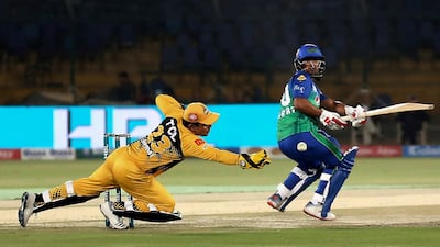 Zeeshan Ashraf of Multan Sultans guides the ball past Peshawar Zalimi's Kamran Akmal. AP