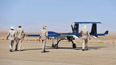 Technicians approach a military unmanned aerial vehicle on a runway. AFP