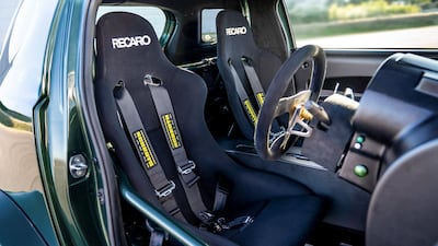 It features including a roll cage and Recaro bucket seats. Aston Martin