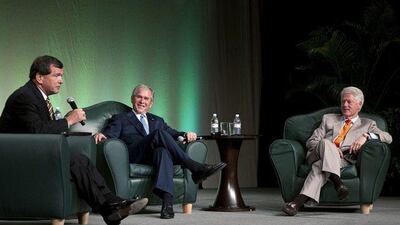 Frank McKenna, left, moderates a discussion in Toronto between the former US presidents George W Bush and Bill Clinton.